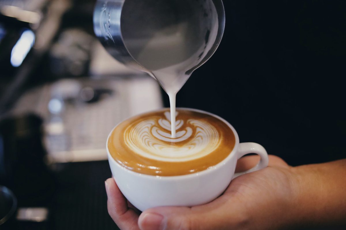 shutterstock_2463928809 | Southern Grace Stays barista pouring latte art into a mug